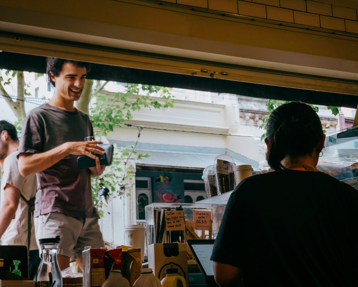 A smiling regular at the café service window